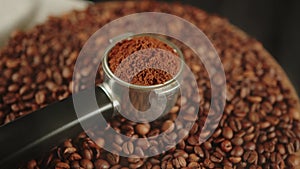 Ground coffee in portafilter on wooden board with coffee beans and dissipating steam. Freshly ground coffee in filter