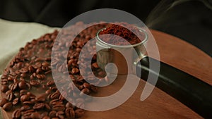 Ground coffee in portafilter on wooden board with coffee beans and dissipating steam. Freshly ground coffee in filter