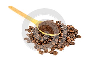 Ground coffee on wooden spoon. Lots of coffee beans scattered on