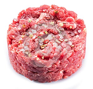 Ground cutlet or raw hamburger with seasonings on white background. Close-up