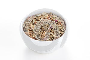 Ground dried Basil in a bowl on white background.