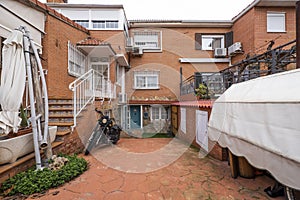 Ground floor of a detached house with a parked black motorcycle and access to the house by stairs with a white metal railing