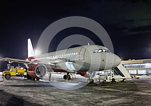 Ground handling passenger aircraft at night winter airport