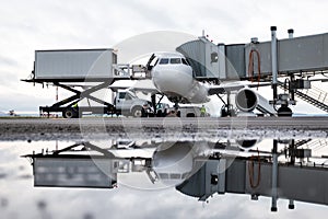 Ground handling of a white passenger aircraft near the air bridge. Loading on-board catering from a truck to an airplane