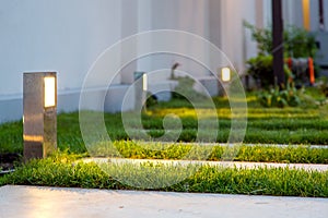 Ground lantern lighting marble walkway in the evening.