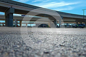 A ground level shot of a freeway over pass with a man in a yellow safety jacket sitting in an SUV