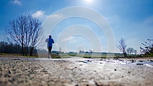 Ground-Level View of Jogger on Rural Road