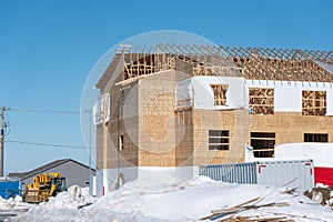 Ground level view of a multifamily apartment complex under construction in winter.