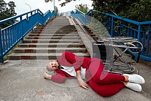 On the ground near the stairs lies a disabled man near the wheelchair. The concept of a wheelchair, disabled person, full life,