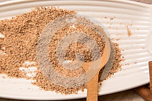 Ground nutmeg spices in a ceramic plate