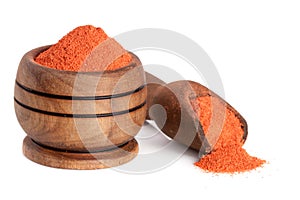 Ground paprika in a wooden bowl with a scoop isolated on a white background