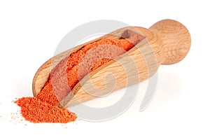 Ground paprika in a wooden scoop isolated on a white background