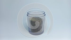 ground pepper in a jar white background