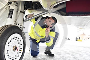 Ground personnel at the airport check the hydraulic system of th