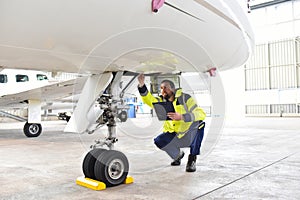 Ground personnel at the airport check the hydraulic system of th