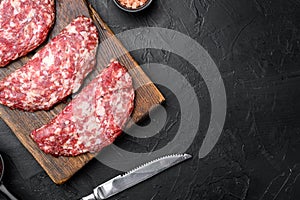 Ground raw meat patties. Meat cutlet ready to cook. Farm organic meat, on black dark stone table background, top view flat lay,