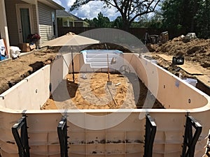 In ground residential swimming pool construction. Prefab walls.