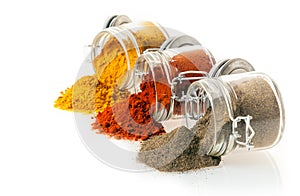 Ground spices spilling from glass jars