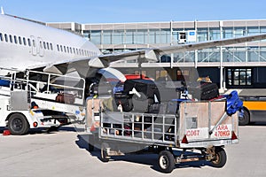 ground staff handling an aircraft before departure at the airport - loading luggage