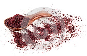 Ground sumac spice in wooden spoon isolated on white background