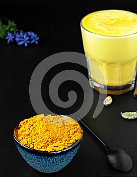 Ground turmeric and other spices for making golden milk from turmeric, black background. A traditional drink to support immunity