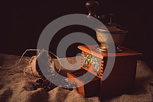 Ground and unground coffee on old sackcloth. Old coffee grinder from our village.