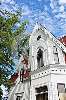 Ground view of gabled tower and porch of an old house from the nineteenth century in historic Sherbrooke Village in Nova Scotia.