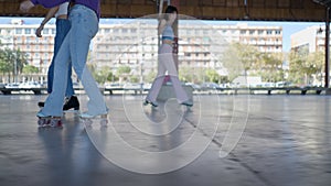 Ground view shot following legs of roller skating girls outdoors