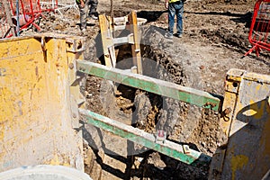 Ground workers installing trench support safety shoring system during deep drainage works on residential housing development photo