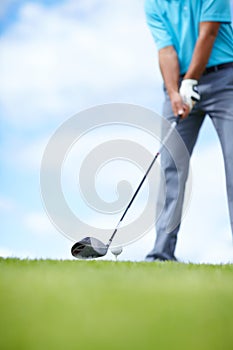 Grounding the club. Cropped image of a young male golfer teeing up to play a shot with his driver.