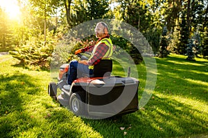 Groundskeeper maintaining lawn with motorized mower