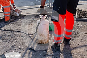 Groundworker cutting asphalt with petrol saw