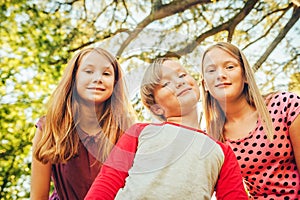 Group of 3 funny kids playing together outside