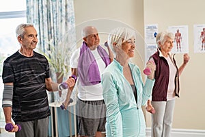 Group of active seniors exercising together at gym