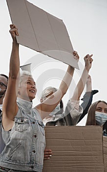 Group of activists giving slogans in a rally. Men and women marching together in a protest in the city.