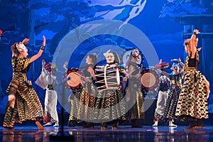 Group of actresses in traditional kimono and hats dancing with taiko drummers on the stage