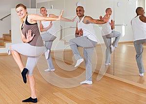 Adult dancers practicing synchronous choreography in studio photo