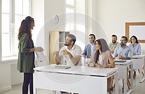 Group of adult students having discussion during class with business college teacher