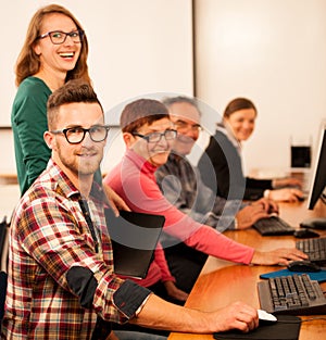 Group of adults learning computer skills. Intergenerational tran