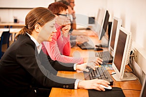 Group of adults learning computer skills. Intergenerational tran