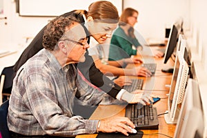 Group of adults learning computer skills. Intergenerational tran