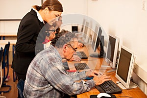 Group of adults learning computer skills. Intergenerational tran