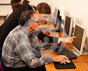 Group of adults learning computer skills. Intergenerational tran