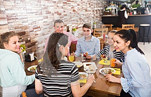 Group of adults and teenagers spending time in cafe