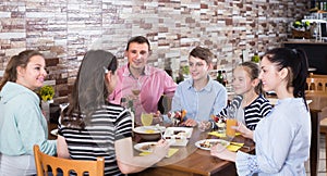 Group of adults and teenagers spending time in cafe