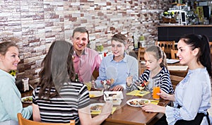 Group of adults and teenagers spending time in cafe