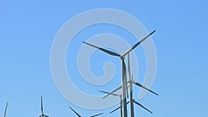 Group of aerogenerators spinning in real-time with a blue sky background