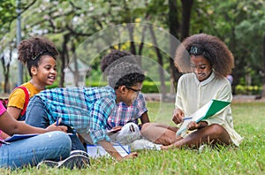 Group of African American children practice drawing in a book and sitting in the park. Education outdoor concept