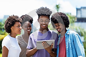 Group of african american young adults posting message with digital tablet photo