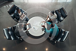 Group of African business people sitting and discussing statistics during a sit down meeting